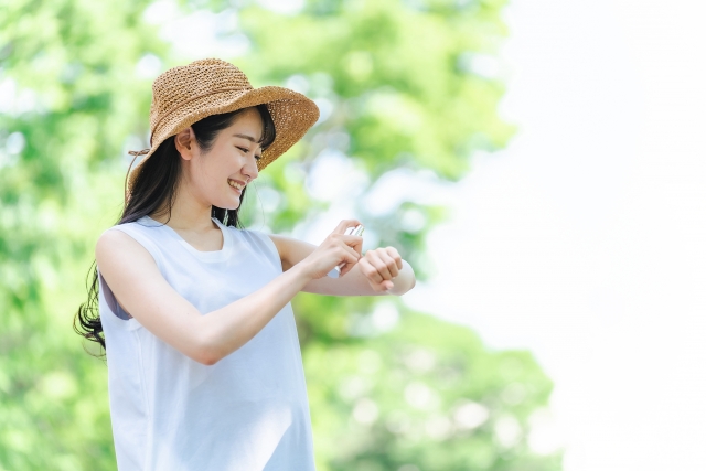 虫よけスプレーを使う女性